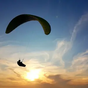 Parapente volant contre un ciel coucher de soleil près de Chaudeyrolles.