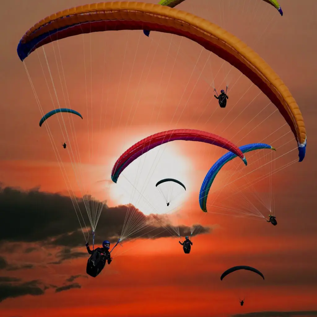 Parapentes planant sur un ciel couchant à Chaudeyrolles.