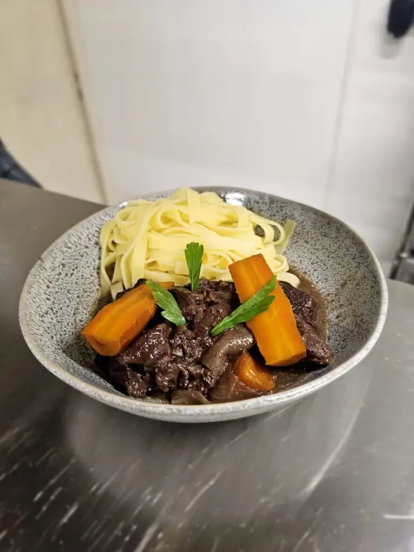 Assiette de fondant de bœuf façon bourguignonne et tagliatelles fraîches maison, servie à l’Auberge Jean le Dindon à Chaudeyrolles